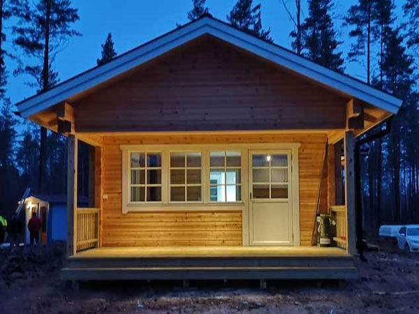 En stuga som lyser på kvällen